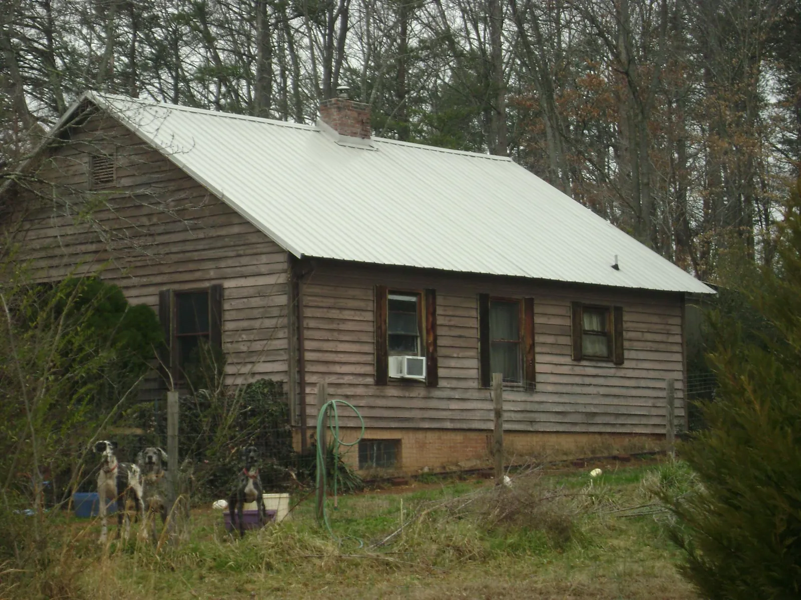 White metal roof on an old wood sided farmhouse, from a Metal Roof Installation job in Lacona